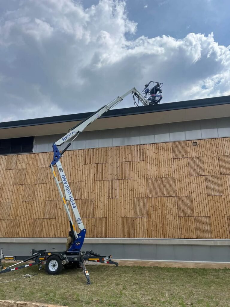 18 m trailer-mounted cherry picker for hire, working at roof height